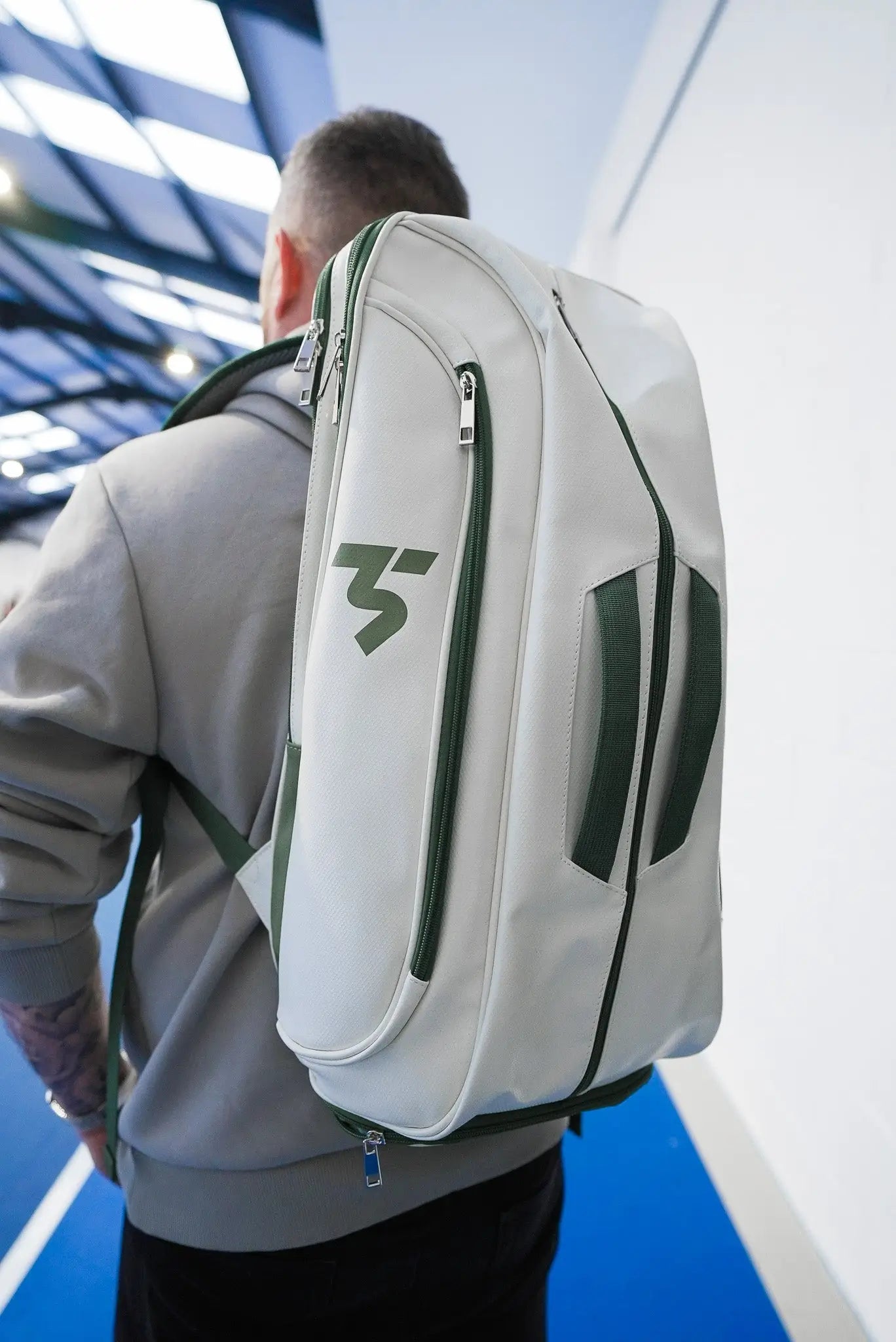 Third Shot game ready sports rucksack worn on court, white and green padel backpack in use
