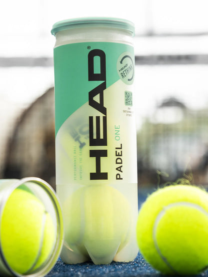 Head Padel One padel balls displayed with open tube and loose balls on a blue padel court surface