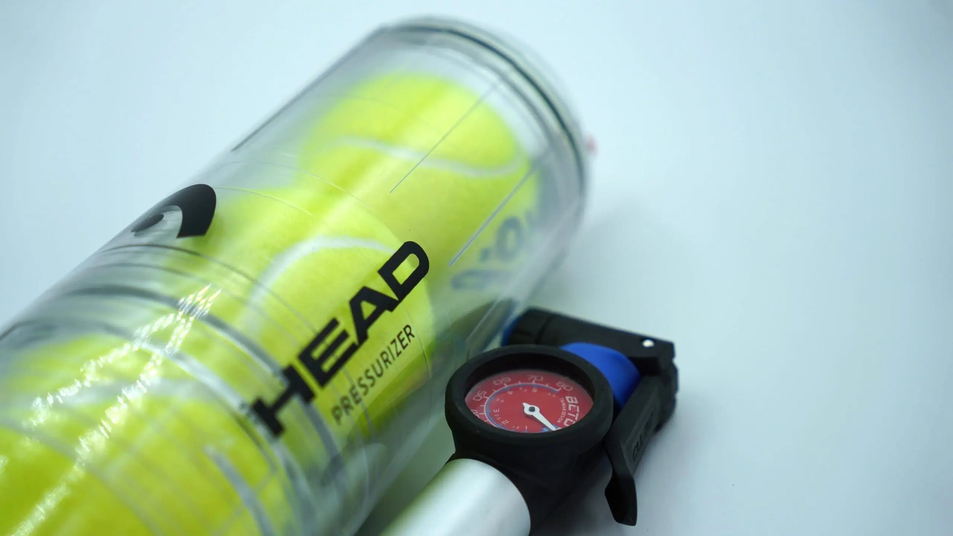 HEAD X4 ball pressuriser with pump and pressure gauge beside transparent tube holding padel balls