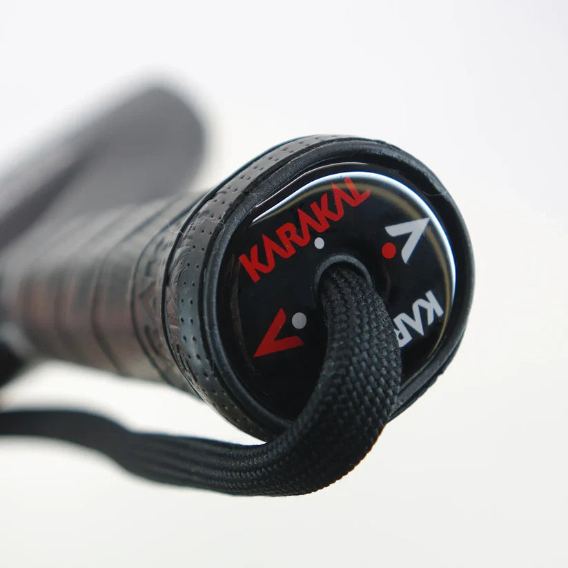 Close-up of Karakal FF PRO butt cap with black X-Air grip and wrist strap, designed for advanced players