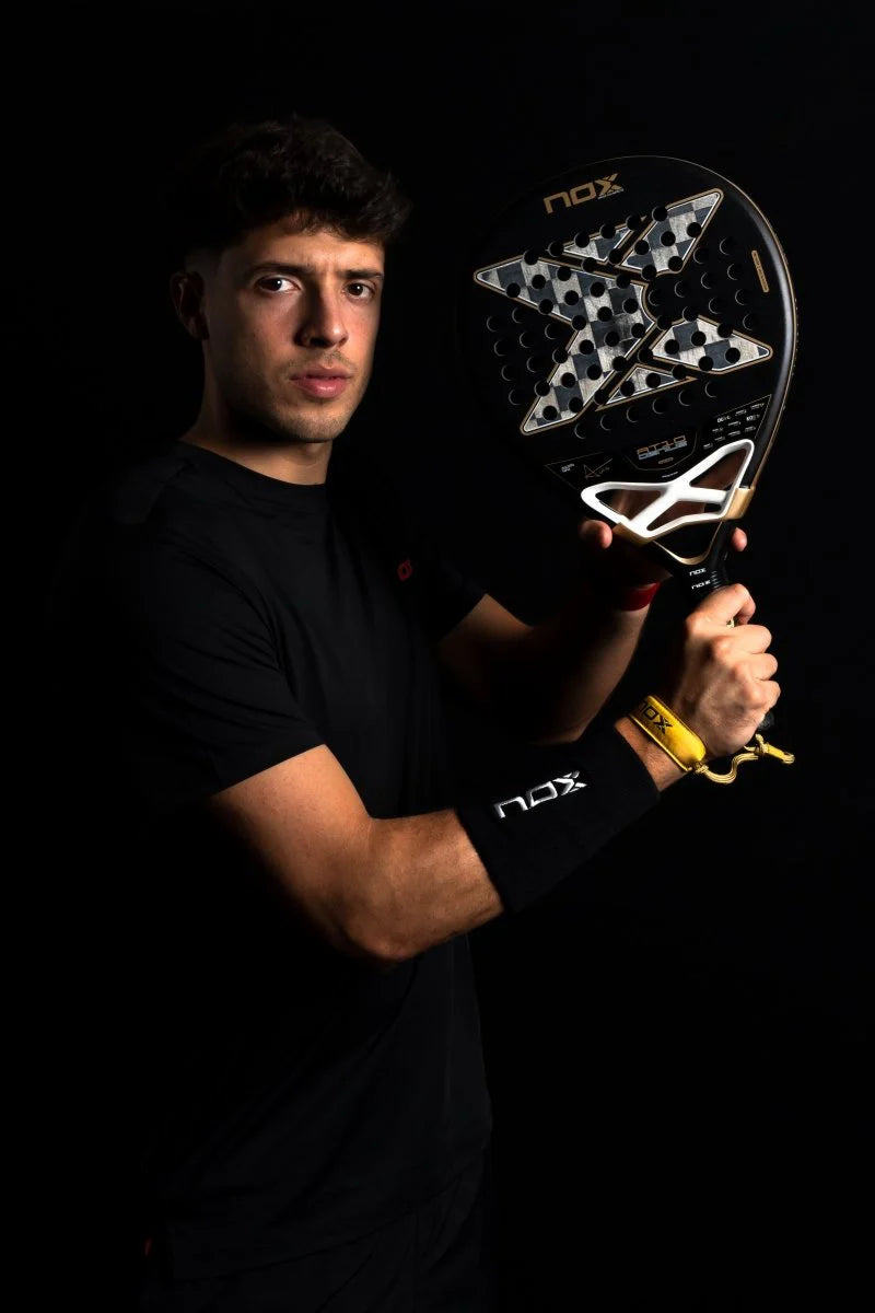 Agustin Tapia holding Nox AT10 Luxury Genius 18K Alum 2026 padel racket in studio setting, designed for advanced players