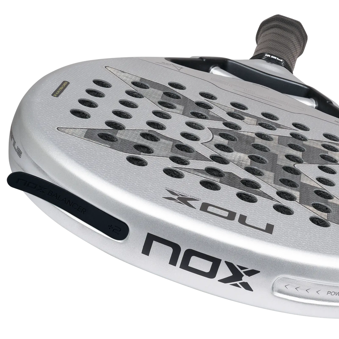 NOX Genius 12K Alum XTREM 2027 close-up showing 12K carbon face, silver frame and black NOX Balancer +2 insert