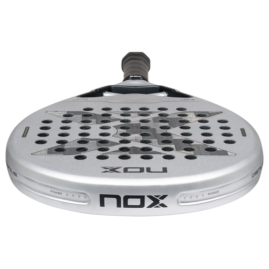 Low-angle close-up of NOX Genius 12K Alum XTREM 2027 padel racket showing its silver head, carbon face and frame edge