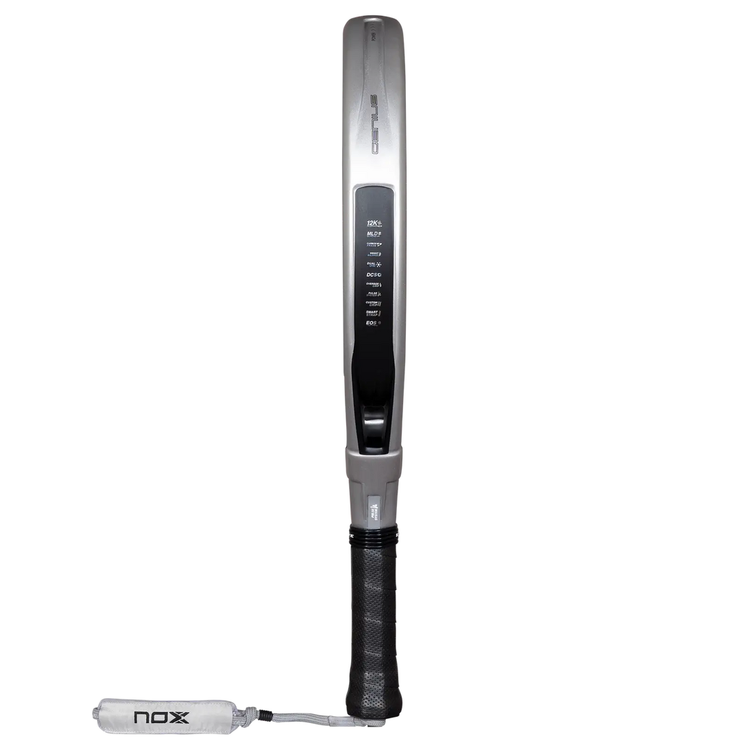 Side profile of the NOX Genius 12K Alum XTREM 2027 padel racket showing its silver frame, black grip and wrist strap