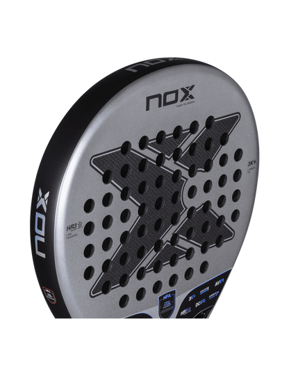 Side view of the Nox Nextgen Pro Hybrid 3K NFA Series padel racket in silver and black with X logo and perforated face, designed for intermediate players.