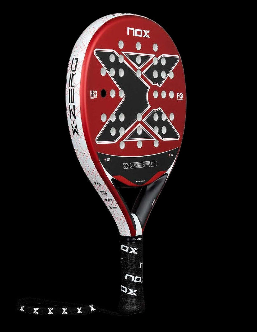 Angled view of the Nox X-Zero Red 26 padel racket in red black and white with X-shaped hole pattern and white frame, designed for beginner players.