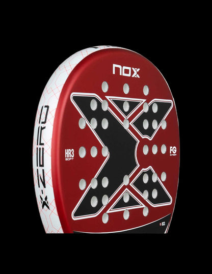 Side view of the Nox X-Zero Red 26 padel racket in red black and white with X-shaped hole layout and white frame, designed for beginner players.