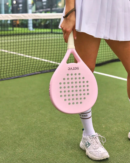 Serve womens padel racket side view held by player standing on padel court, designed for women players.