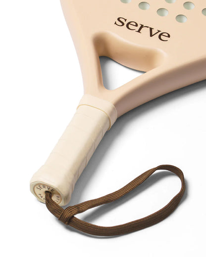Serve womens padel racket handle close up showing grip and wrist strap detail, designed for women players
