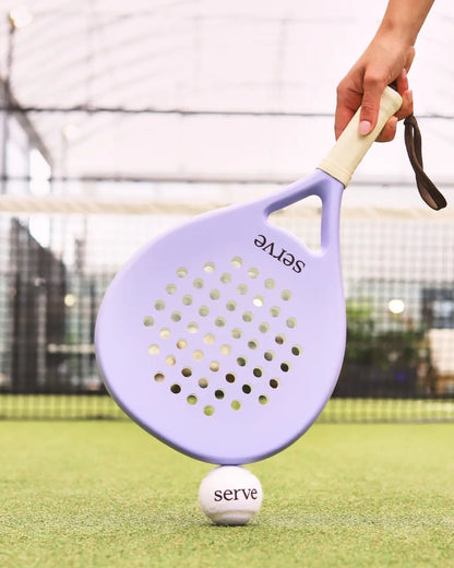 Serve womens padel racket balanced on padel ball on court surface, designed for women players