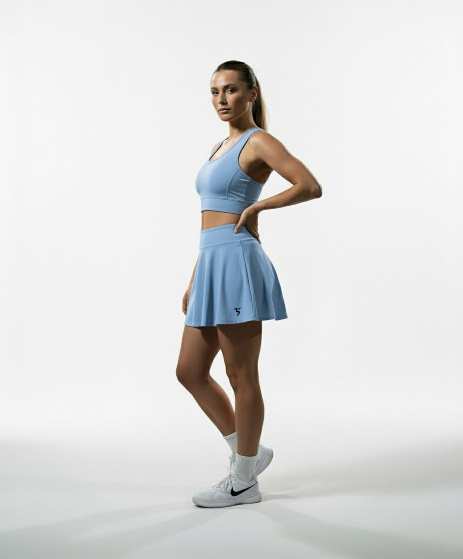 model wearing Third Shot women’s performance skort in powder blue side view showing high rise fit, designed for all level players