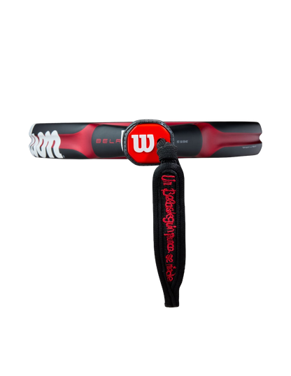 Close-up of the Wilson Bela V3 2025 padel racket handle showing the red Wilson logo and black wrist strap, designed for advanced players
