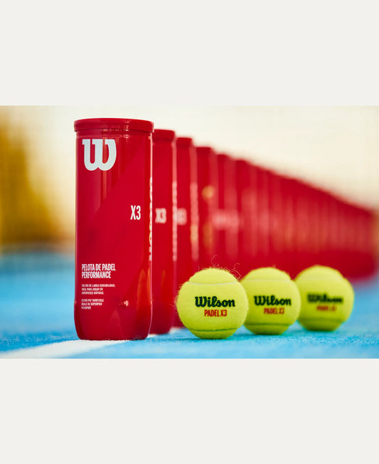 Wilson Padel X3 padel balls with multiple red tubes lined up on a blue padel court surface