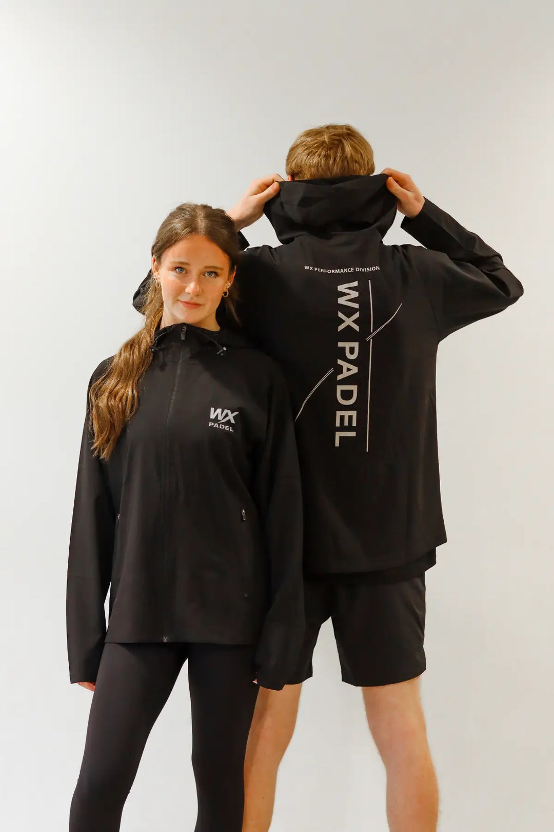 Male and female players wearing WX Padel Technical Full-Zip Hoodies with Performance Division rear print
